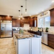 Remodeled Kitchen with granite stone countertop and sink on center island 